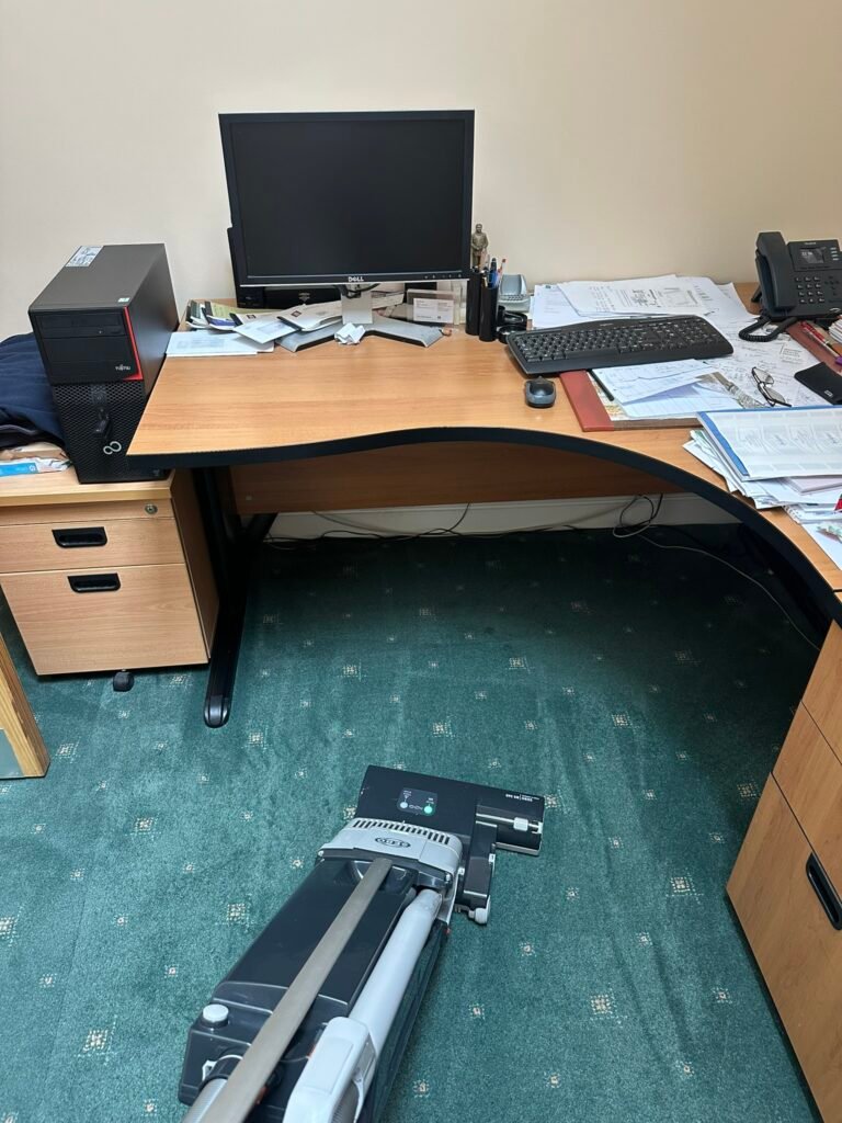 Professional carpet cleaning machine working on green patterned office carpet under a desk in a Dublin office