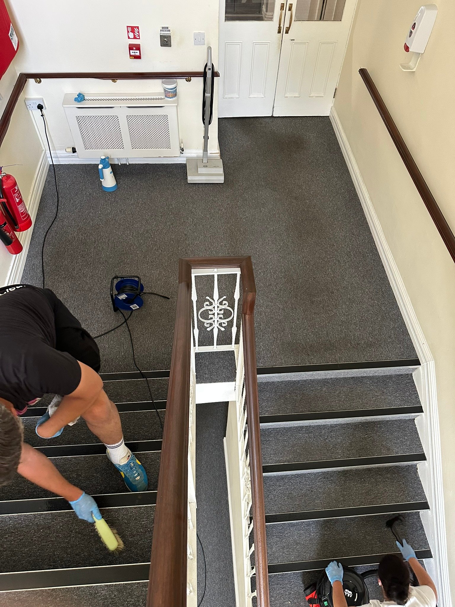 Hot water extraction carpet cleaning machine used on hotel staircase and landing